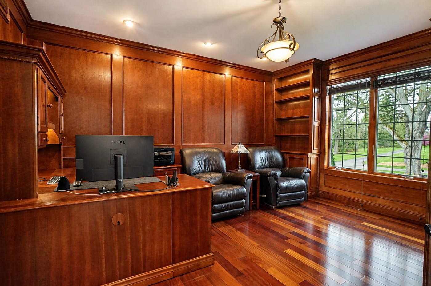 Cherry-paneled office with fireplace and built-in bookcases at 60675 Pontiac Trail